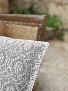 Gray and white pillow with stitch embroider detail. Handwoven textile.