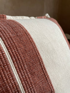 Woven detail on striped pillow.