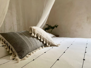 Chambray pillow with fringe. Cotton handwoven pillow. Displayed with black and white stripe blanket and throw pillow.