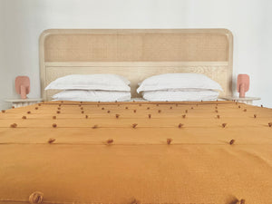 Golden striped bedcover in elegant room. Handwoven blanket.