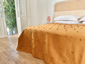 Golden orange bedcover with texture detail.
