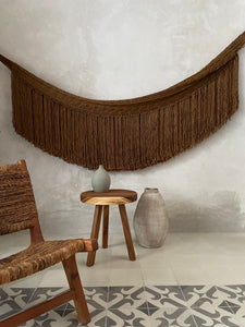 Gold woven hammock with fringe in Yucatan villa with tile floor.