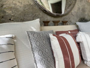 Collection of striped and textured pillows in tulum-style home.