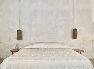 Textured white blanket in minimalist interior design. Handmade artisan blanket.