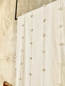 Textured white blanket with woven handmade design.