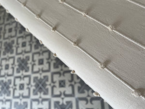 Woven knot detail on white bedcover.