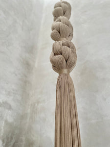 Giant woven tassel hanging in room. 