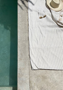 White and black striped blanket with dash pattern next to a pool in Mexico.