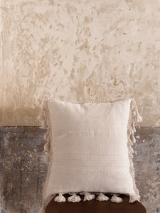 White cream pillow with fringe. Cotton handwoven pillow. On a chair in Mexican villa.